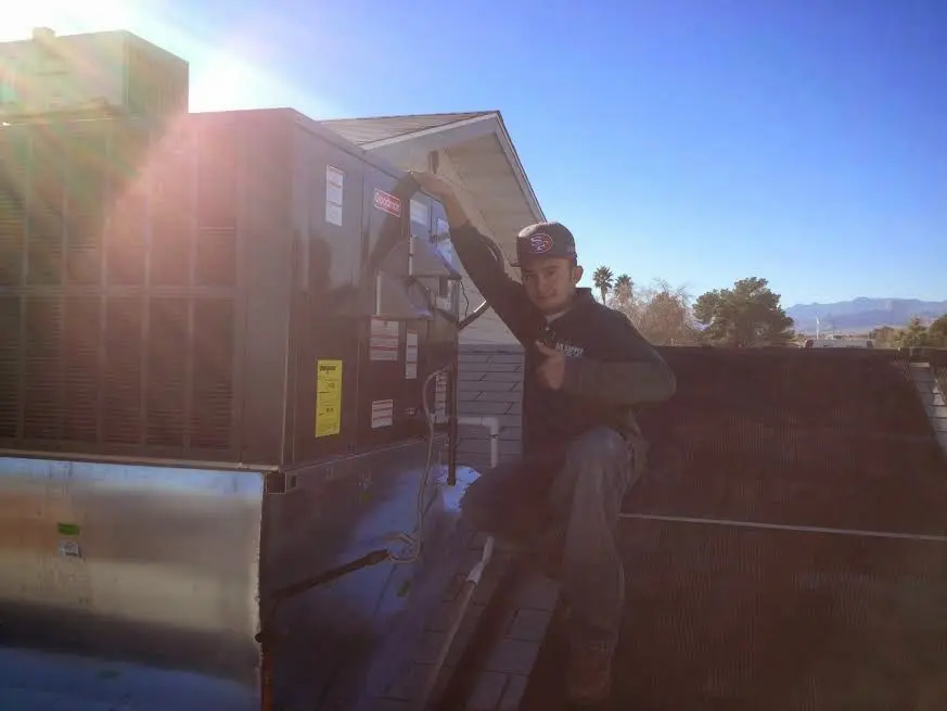 HVAC technician performing Air Duct Repair on a rooftop unit in Mount Hope